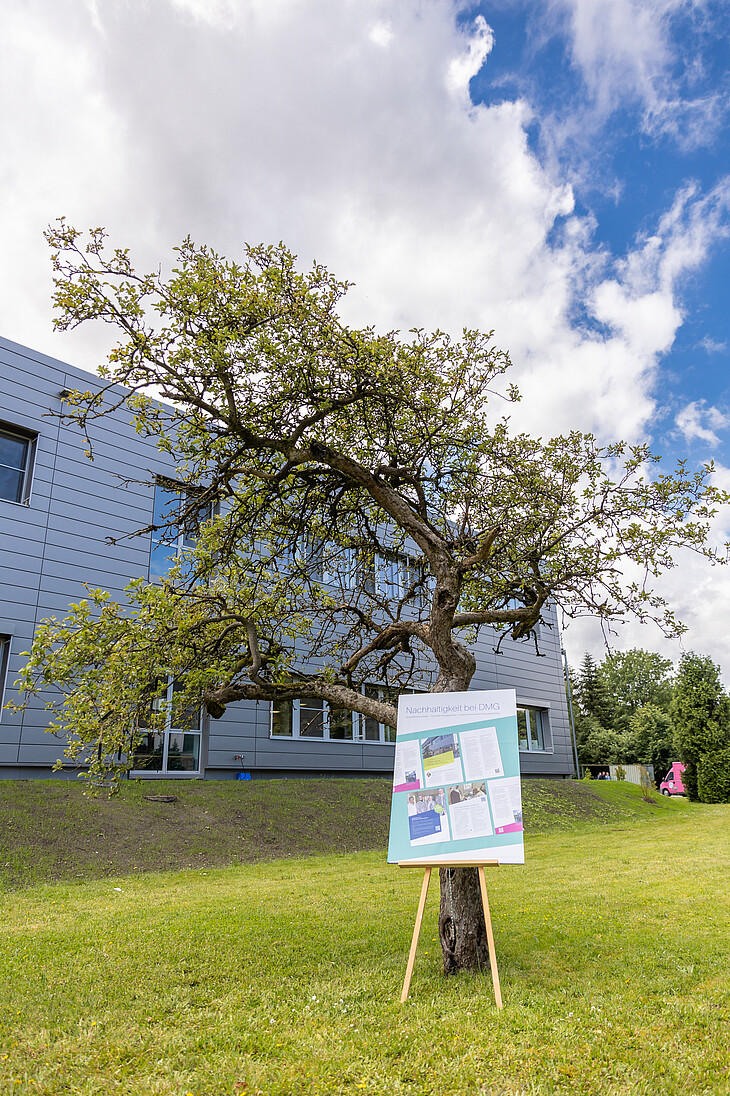 The DMG WishTree in front of a modern production building