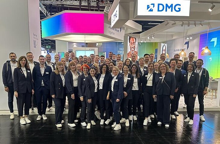 The whole DMG team in front of the IDS stand