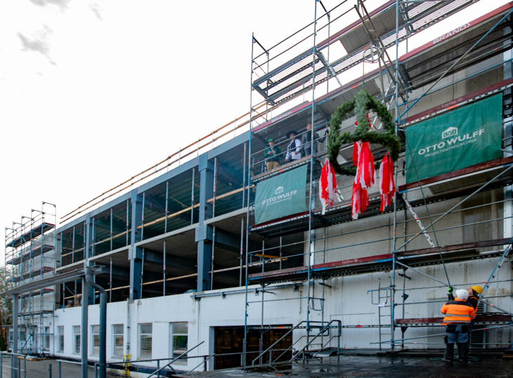 Photo of the new DMG production building structure with topping-out wreath